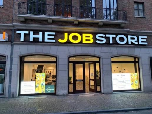 De winkelpui van The Job Store met het verlichte naambord.